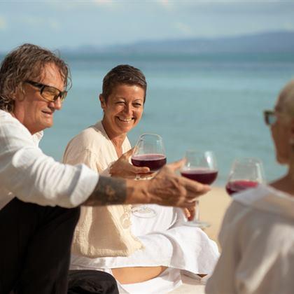 Older friends enjoying drinks by the beach